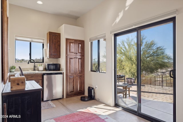 kitchen featuring dishwasher, light tile patterned floors, plenty of natural light, and sink