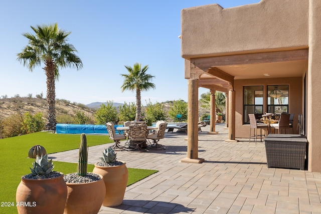 view of patio with a mountain view and a covered pool