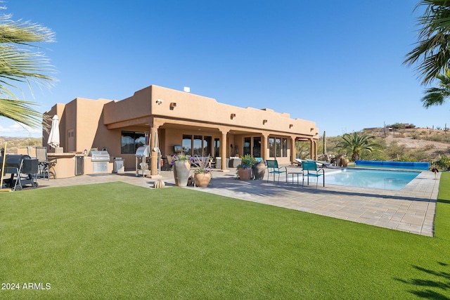 rear view of property with area for grilling, a patio area, and a yard