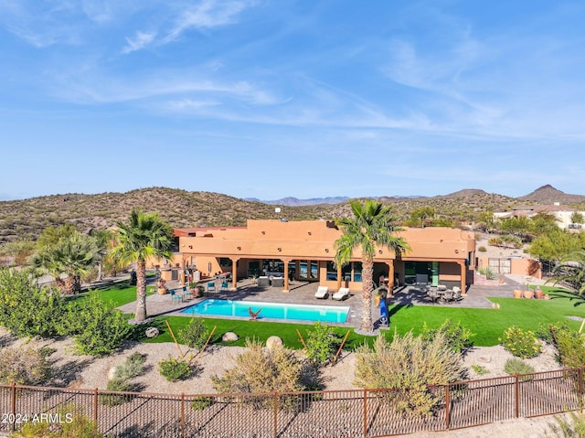 view of pool with a lawn, a mountain view, a patio area, and an outdoor living space