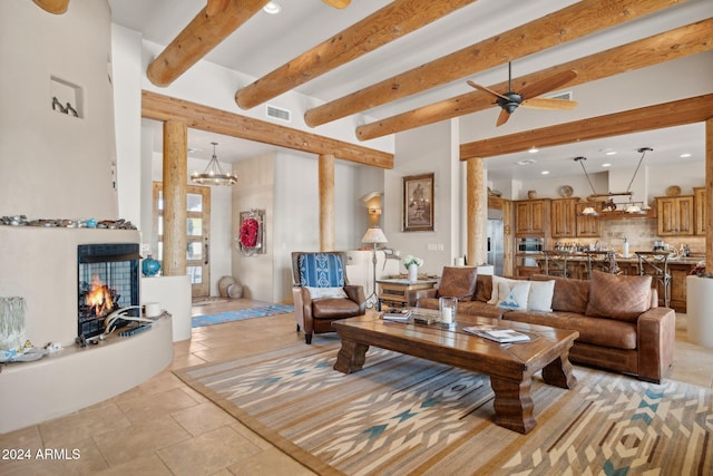 living room featuring beam ceiling and ceiling fan with notable chandelier