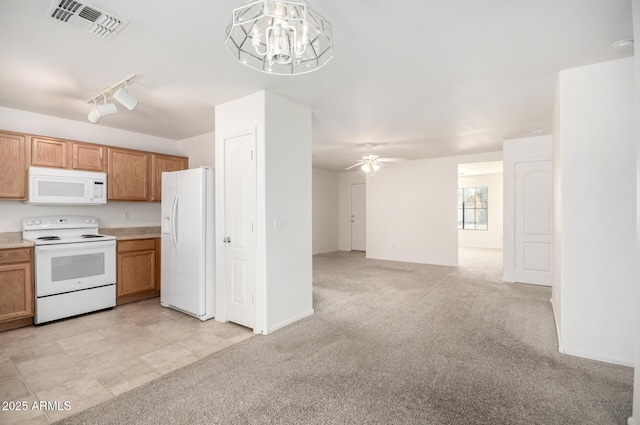 kitchen with light carpet, hanging light fixtures, white appliances, and rail lighting