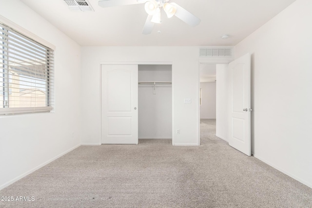 unfurnished bedroom with ceiling fan, light colored carpet, and a closet