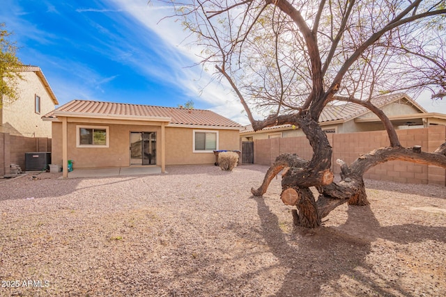 back of property with cooling unit and a patio