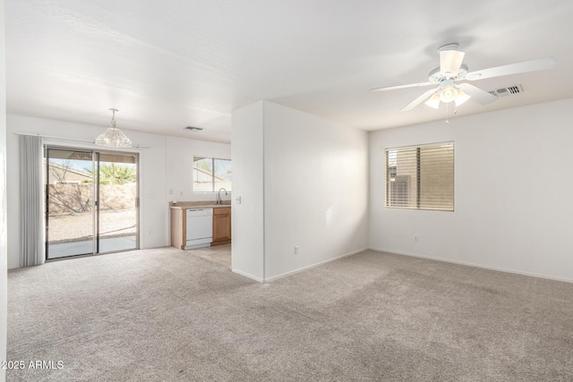 unfurnished living room featuring sink, light colored carpet, and ceiling fan