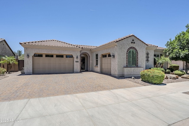 22255 E Quintero Rd, Queen Creek, AZ 85142 - mediterranean / spanish-style home featuring decorative driveway, an attached garage, a tile roof, and stucco siding