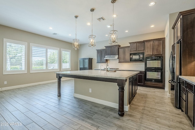 22255 E Quintero Rd, Queen Creek, AZ 85142 - kitchen featuring black appliances, under cabinet range hood, a kitchen island with sink, recessed lighting, and light wood-style floors
