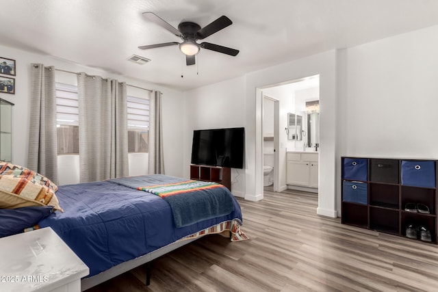 bedroom featuring ceiling fan, connected bathroom, and light wood-type flooring