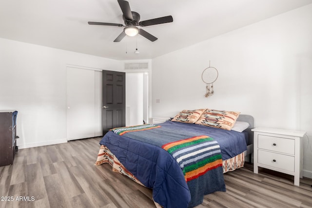 bedroom featuring ceiling fan, a closet, and light wood-type flooring