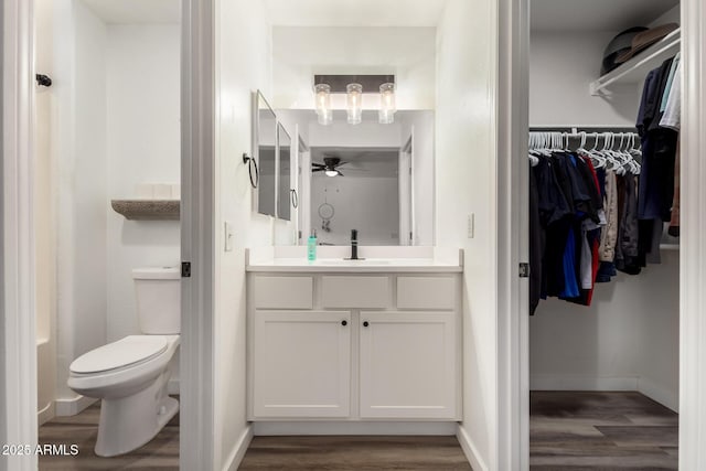 bathroom featuring vanity, ceiling fan, hardwood / wood-style flooring, and toilet