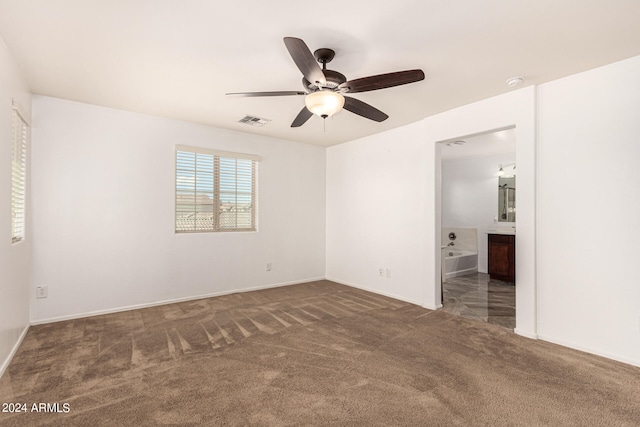 carpeted spare room featuring ceiling fan