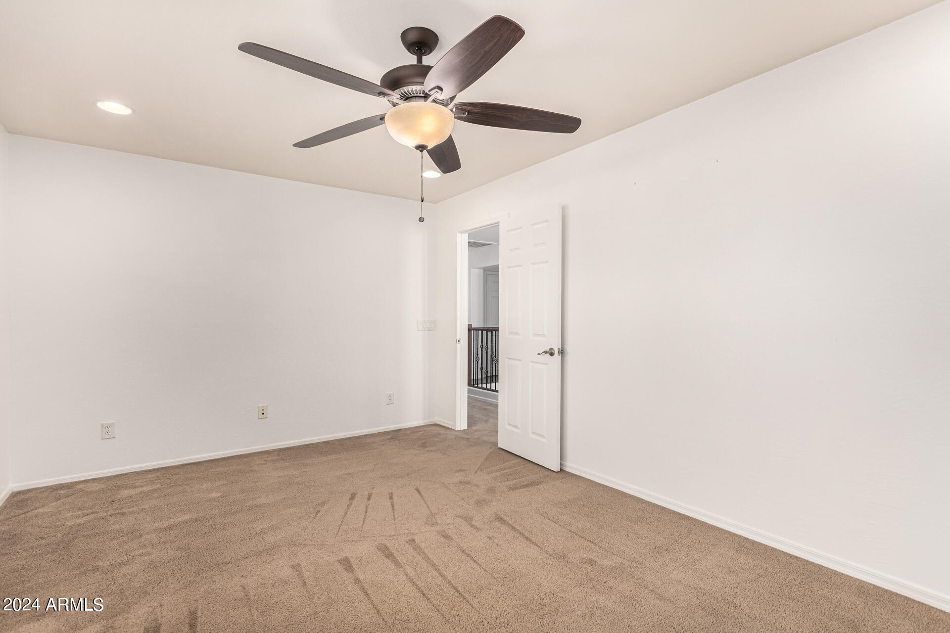 carpeted empty room featuring ceiling fan