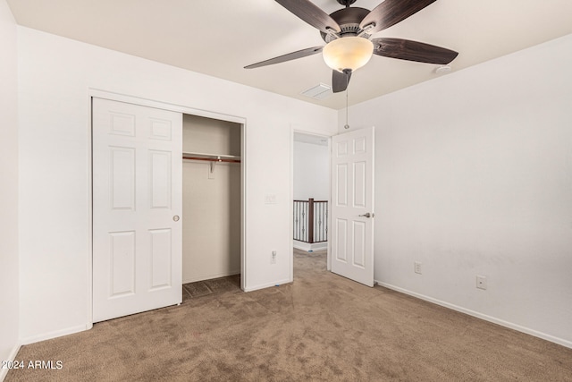 unfurnished bedroom with light carpet, ceiling fan, and a closet