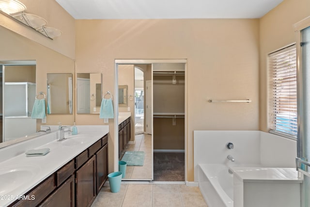 bathroom featuring a tub to relax in, vanity, and tile patterned floors