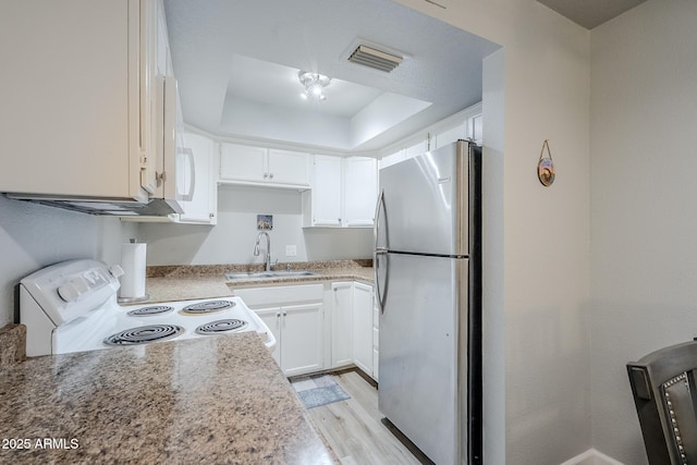 17 E Ruth Ave Unit 303, Phoenix, AZ 85020 - kitchen with freestanding refrigerator, a sink, white electric range oven, white cabinetry, and light wood-style floors