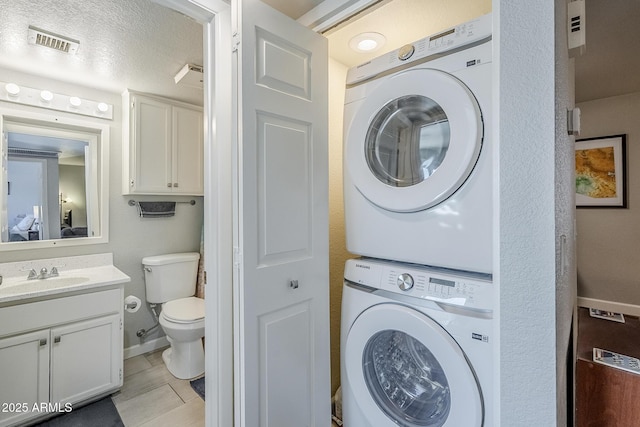 17 E Ruth Ave Unit 303, Phoenix, AZ 85020 - washroom featuring estacked washer and dryer and baseboards