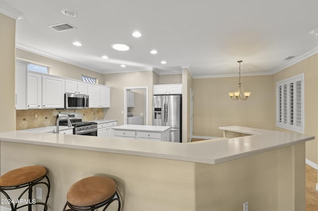 kitchen featuring white cabinets, stainless steel appliances, a center island, a breakfast bar area, and crown molding