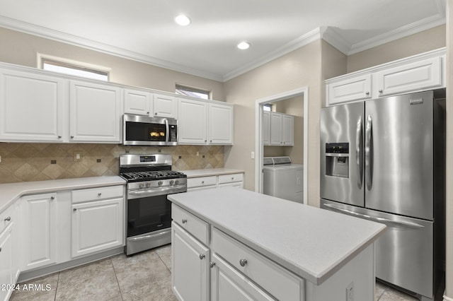 kitchen with decorative backsplash, crown molding, separate washer and dryer, stainless steel appliances, and white cabinetry