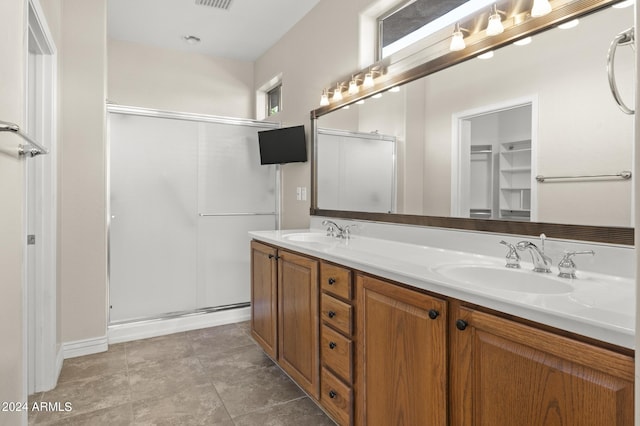 bathroom featuring a shower with door and vanity