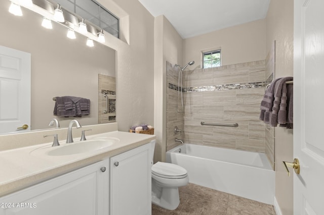 full bathroom featuring tile patterned flooring, tiled shower / bath, vanity, and toilet