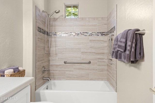 bathroom with tiled shower / bath and vanity