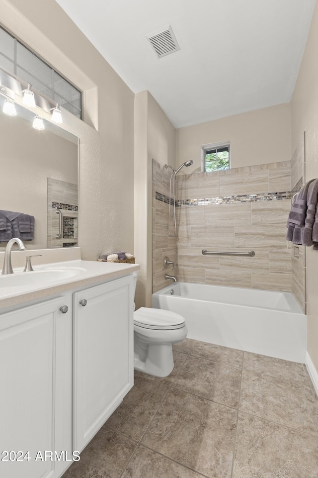 full bathroom featuring tile patterned floors, vanity, toilet, and tiled shower / bath combo