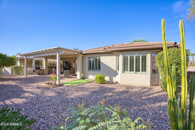 rear view of house featuring a pergola and a patio