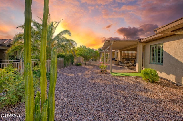 yard at dusk featuring a patio