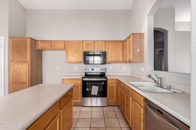 kitchen featuring light tile patterned flooring, appliances with stainless steel finishes, sink, and a high ceiling