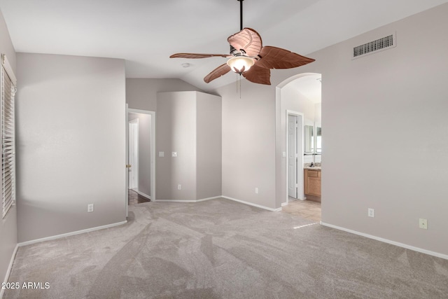 carpeted empty room featuring ceiling fan and vaulted ceiling