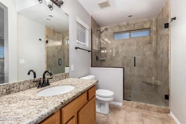 bathroom featuring walk in shower, vanity, toilet, and tile patterned flooring