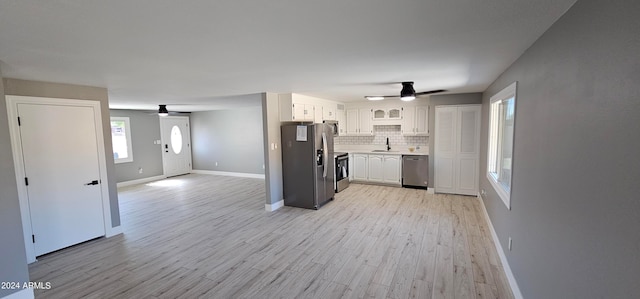 kitchen featuring white cabinetry, appliances with stainless steel finishes, backsplash, sink, and light hardwood / wood-style floors