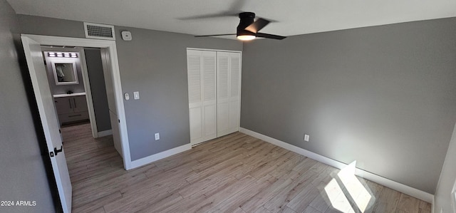 unfurnished bedroom with a closet, sink, ceiling fan, and light hardwood / wood-style flooring