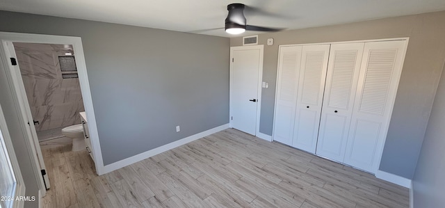 unfurnished bedroom with ensuite bathroom, light wood-type flooring, ceiling fan, and a closet