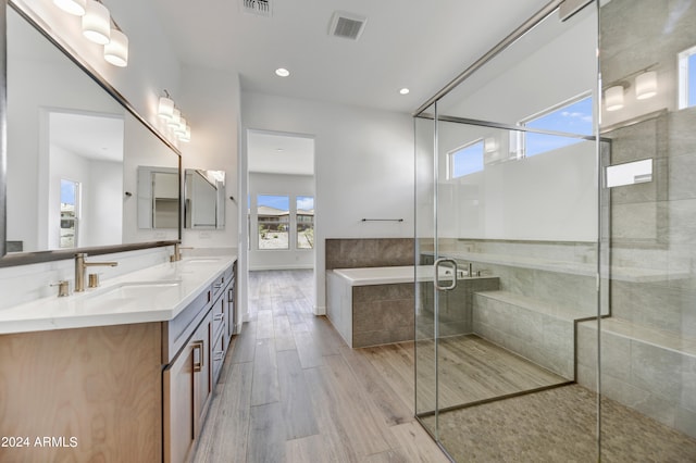 bathroom featuring hardwood / wood-style floors, vanity, and separate shower and tub