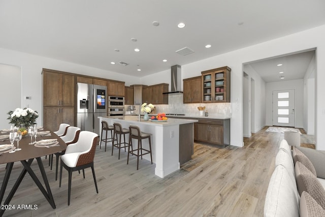 18203 E Paria Canyon Dr, Rio Verde, AZ 85263 - kitchen with stainless steel appliances, wall chimney exhaust hood, light wood-style floors, decorative backsplash, and recessed lighting