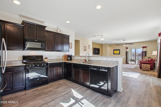 kitchen featuring sink, kitchen peninsula, light hardwood / wood-style floors, and black appliances