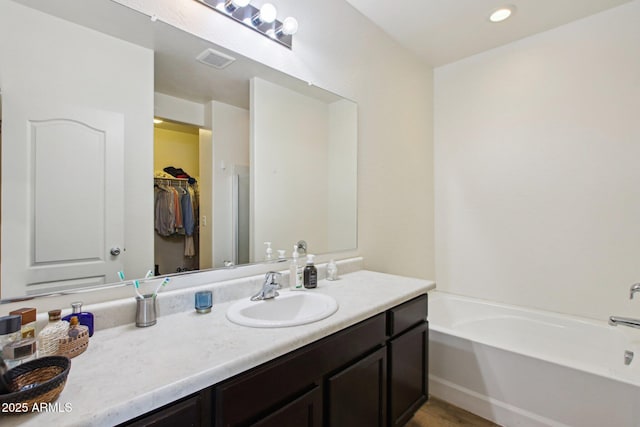 bathroom featuring vanity and a bath