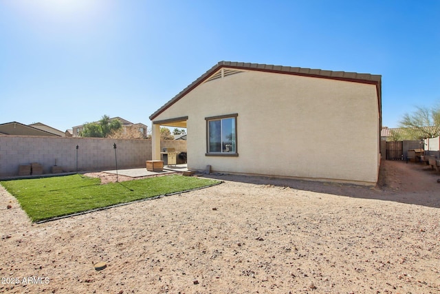 back of property featuring a patio and a yard