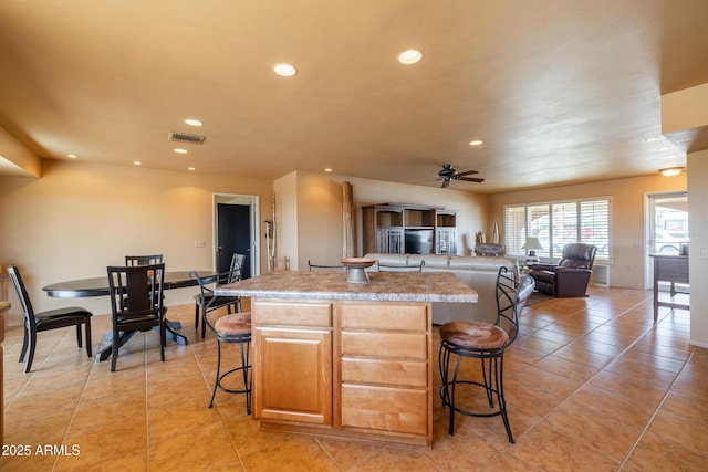 kitchen featuring open floor plan, a breakfast bar area, recessed lighting, and a center island