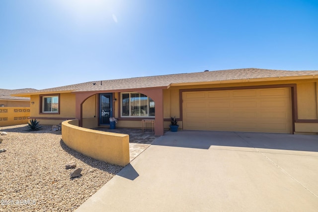 ranch-style house featuring driveway, an attached garage, and stucco siding