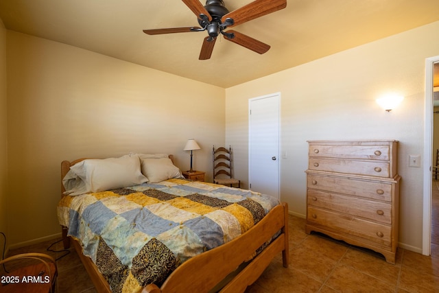 bedroom with a ceiling fan, tile patterned flooring, and baseboards