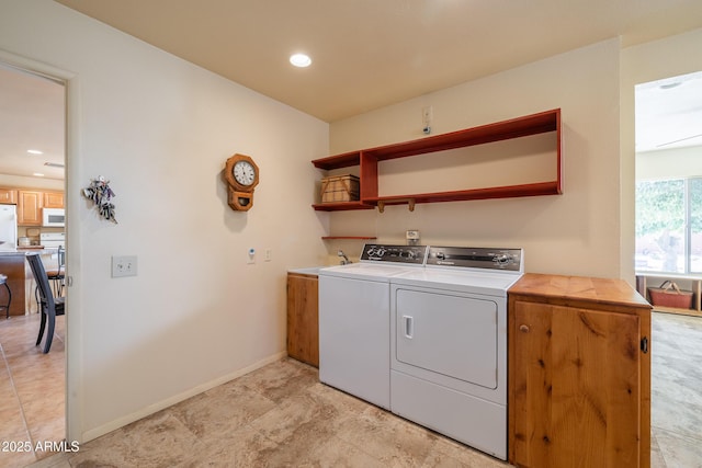 laundry area featuring recessed lighting, cabinet space, a sink, independent washer and dryer, and baseboards