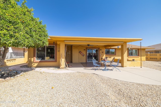 rear view of house featuring a patio, a ceiling fan, and stucco siding