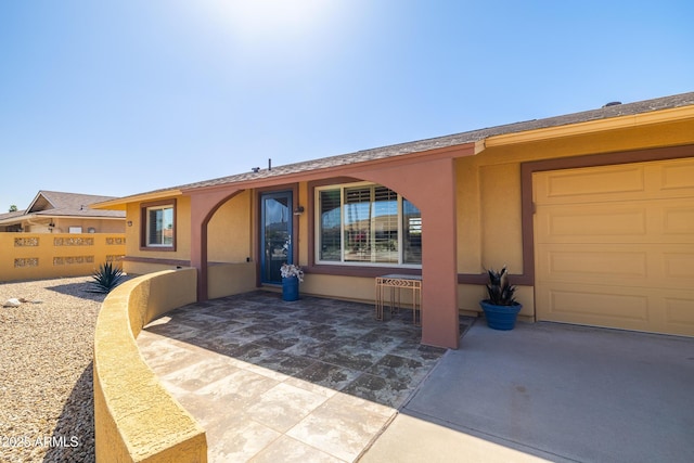 view of front of property featuring a patio, fence, and stucco siding