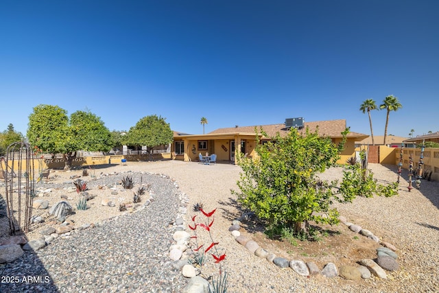 view of front of home with a patio area, fence, and stucco siding