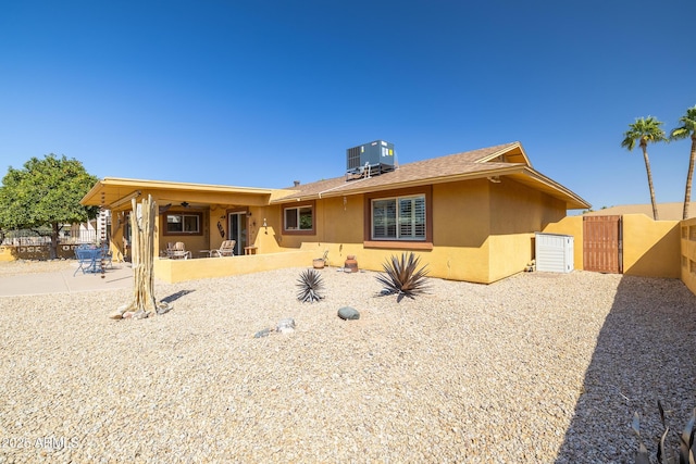 back of house with a patio, central AC unit, fence, a gate, and stucco siding