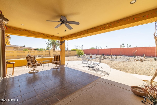 view of patio featuring a ceiling fan, outdoor dining area, and a fenced backyard