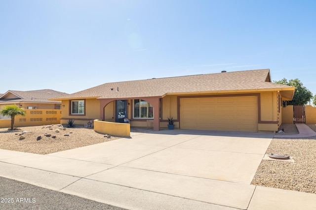 ranch-style house featuring a garage, driveway, fence, and stucco siding