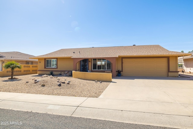 ranch-style house featuring an attached garage, roof with shingles, concrete driveway, and stucco siding